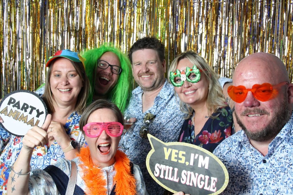 Friends enjoying props and laughter in the open-air photo booth